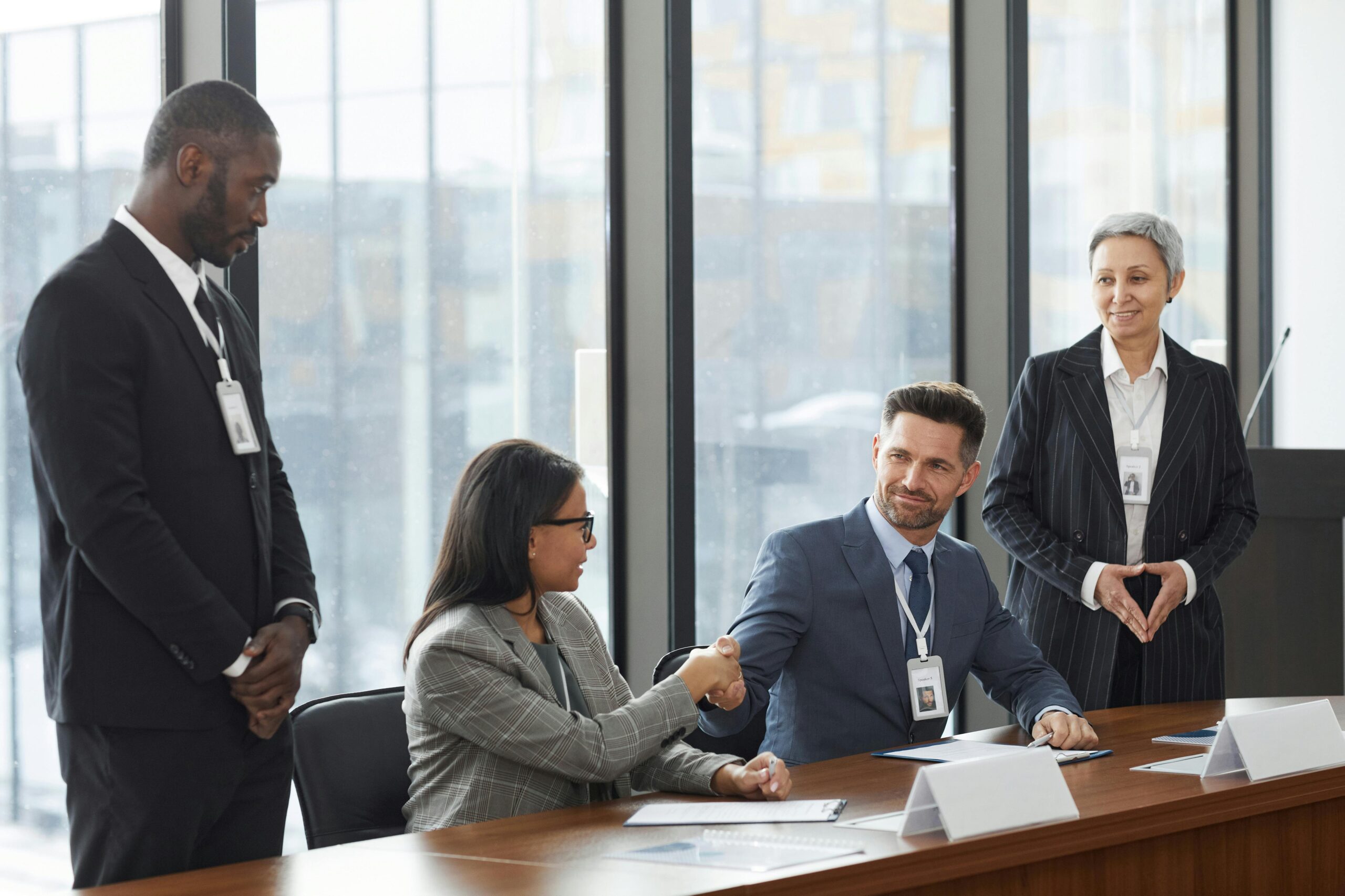 A diverse group of professionals shaking hands during a business meeting in a modern office.
